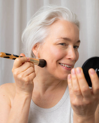 Frau mit JACKS beauty line Foundationpinsel in der Hand und Powder Compact