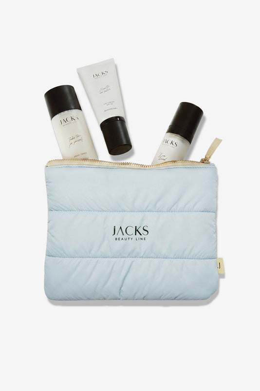 JACKS beauty line Logo auf einer hellblauen Tasche mit hellgelben Zipper und Skincare Produkten 