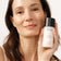 Frau hält JACKS beauty line Milky Toner in der Hand neben ihr Gesicht