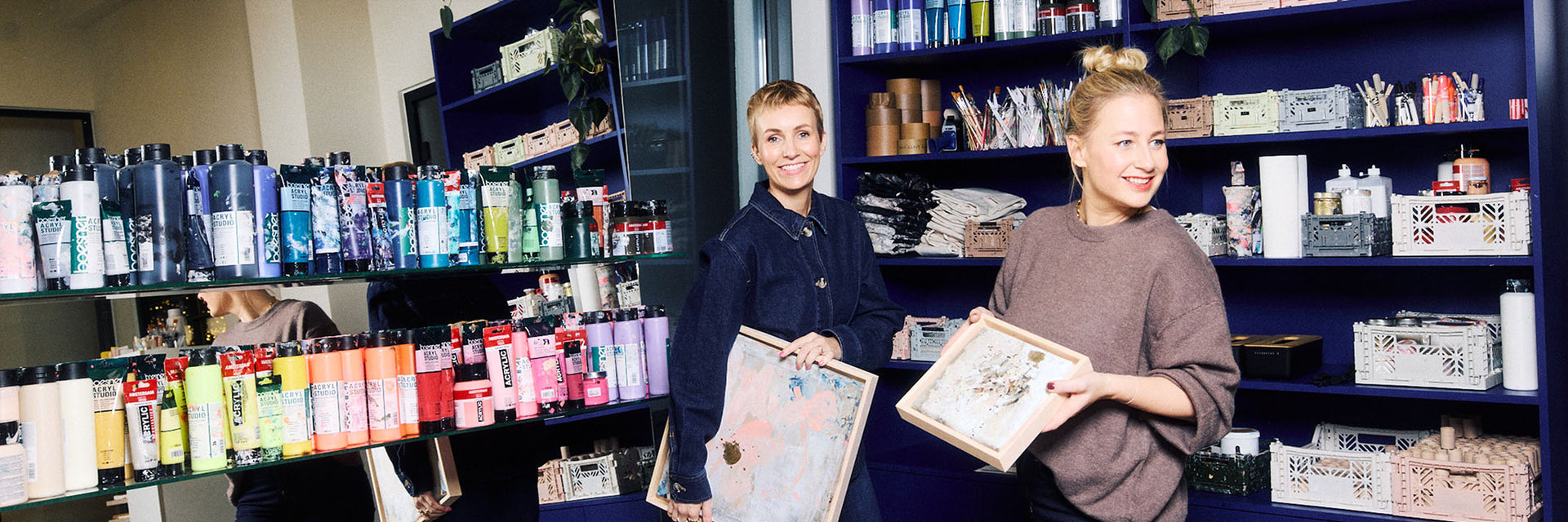 Miriam Jacks und Lisa Buchholz halten farbige Leinwände