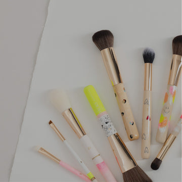 9 nebeneinanderliegende bunte handbemalte Make-up Pinsel