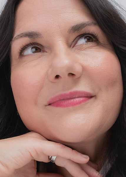 Frau mit dunklen Haaren und Rosacea mit Make-up