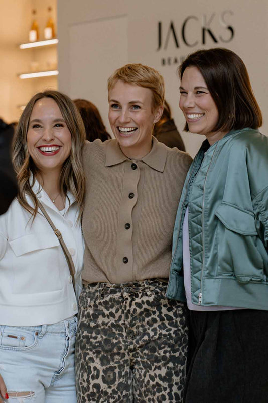 Miriam Jacks steht zwischen zwei anderen Frauen und umarmt diese lächelnd