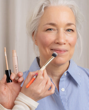 Frau Ü40 bekommt den JACKS beauty line Cream Concealer mit dem Concealerpinsel aufgetragen