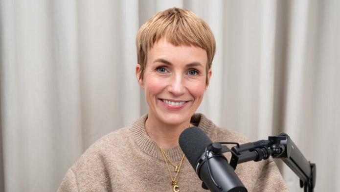 Miriam Jacks lächelt und sitzt vor einem Mikrofon