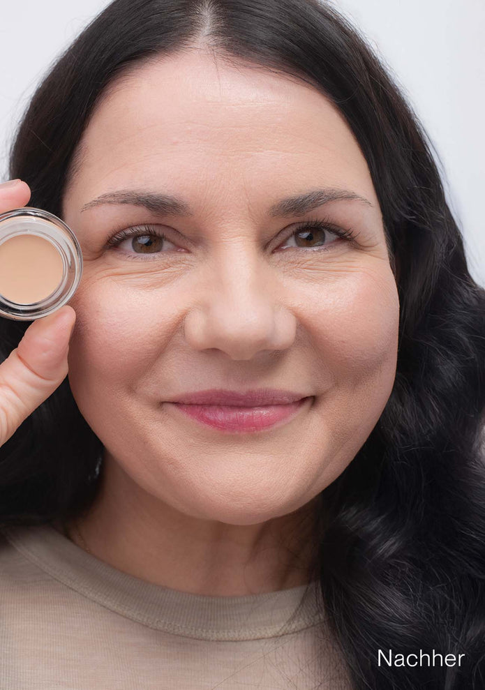 Frau mit JACKS beauty line Cover Concealer im Gesicht und Tiegel in der Hand