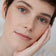 #farbwunsch_n-1, Frau mit JACKS beauty line Cover Foundation N.1 Swatch im Gesicht und Flakon in der Hand