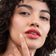 #farbwunsch_coral, Braunhaarige Frau trägt den JACKS beauty line Lipstick in Coral