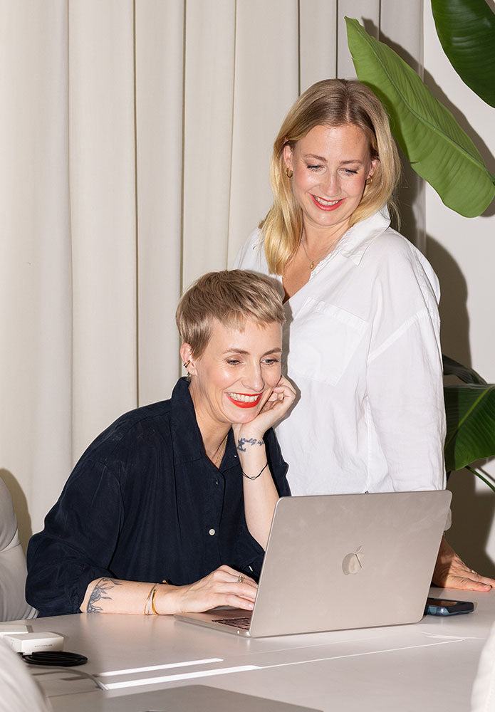 Gründerinnen Miriam Jacks und Lisa Buchholz schauen in ein MacBook
