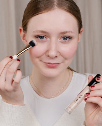 Eine Teenagerin trägt den JACKS beauty line Cream Concealer mit dem Concealerpinsel auf