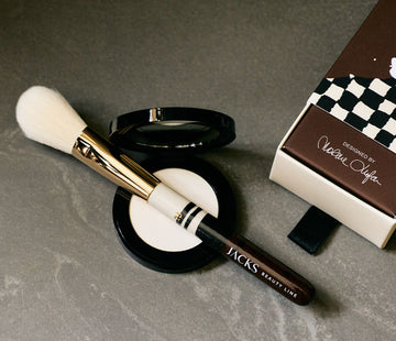 JACKS Puderpinsel liegt auf einem offenen Perfecting Powder