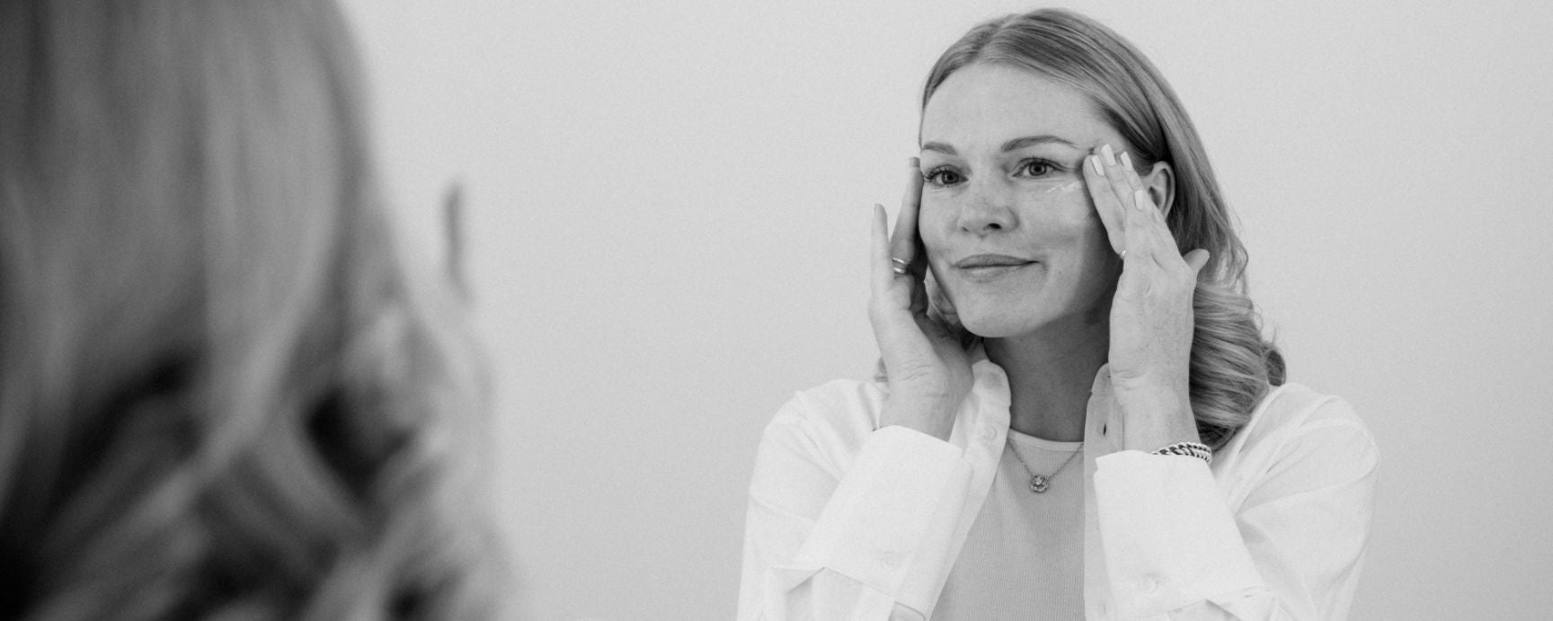 Leonie Scholl trägt Augencreme mit ihren Händen auf